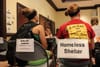 Image of group participating in Poverty simulation. Signs hanging from back of chair.