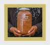 Image of Black woman hold soil collection jar to commemorate lynching of George Green on November 16, 1933, in Greenville, SC